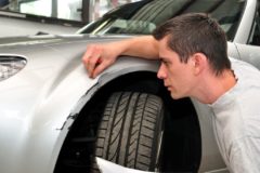 Car insurance expert, inspecting car damage after a crash.